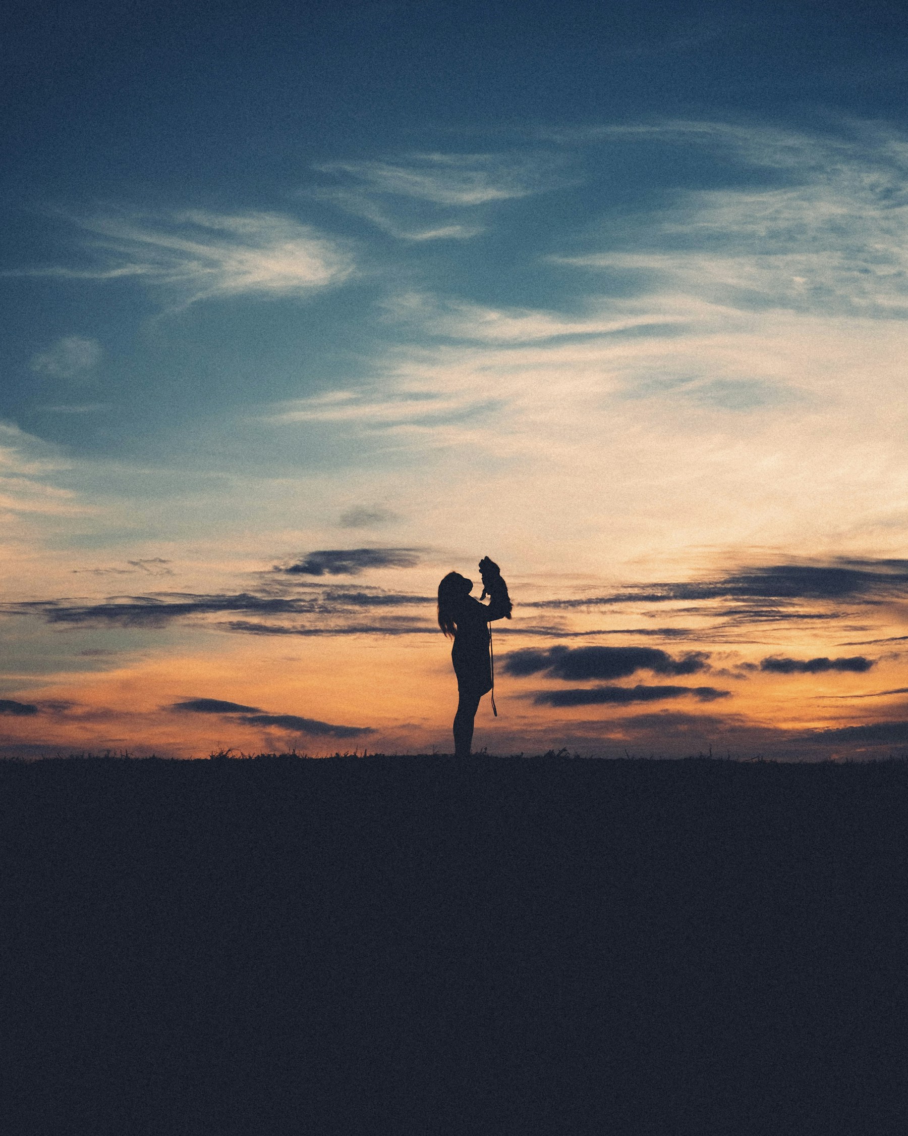 Vater und Kind als ruhige Silhouetten im Abendlicht