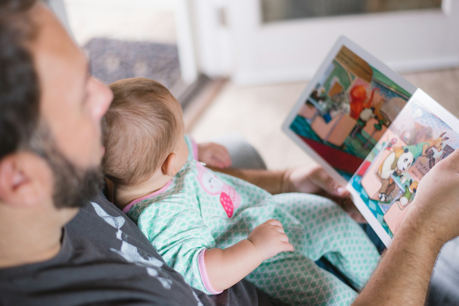 Vater und kleines Kind lesen ruhig gemeinsam ein Bilderbuch